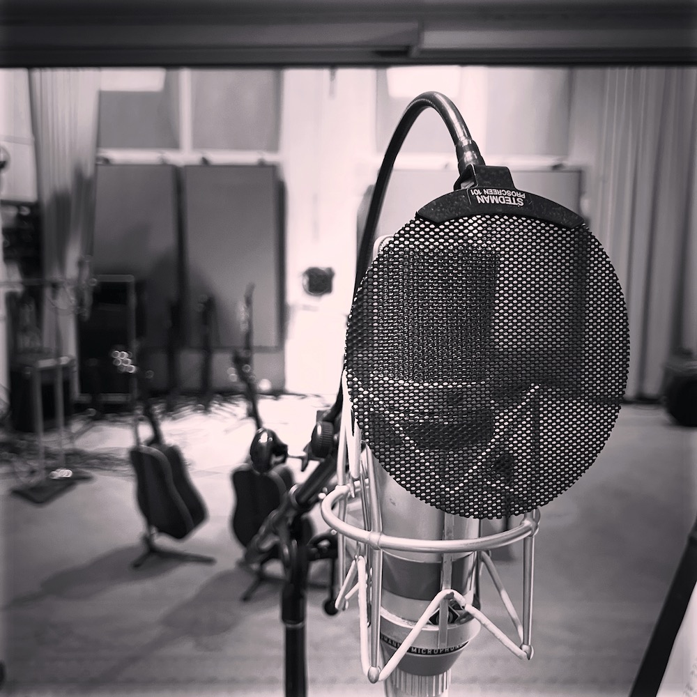 A black-and-white photo ot the view from behind a very expensive microphone.